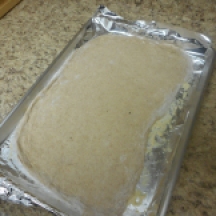 Roll the dough into rectangle or oblong shape, 1/4 inch thickness, place on oiled baking sheet that's been sprinkled with cornmeal....